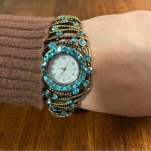 Perennial Quartz aqua rhinestone gold tone watch.
